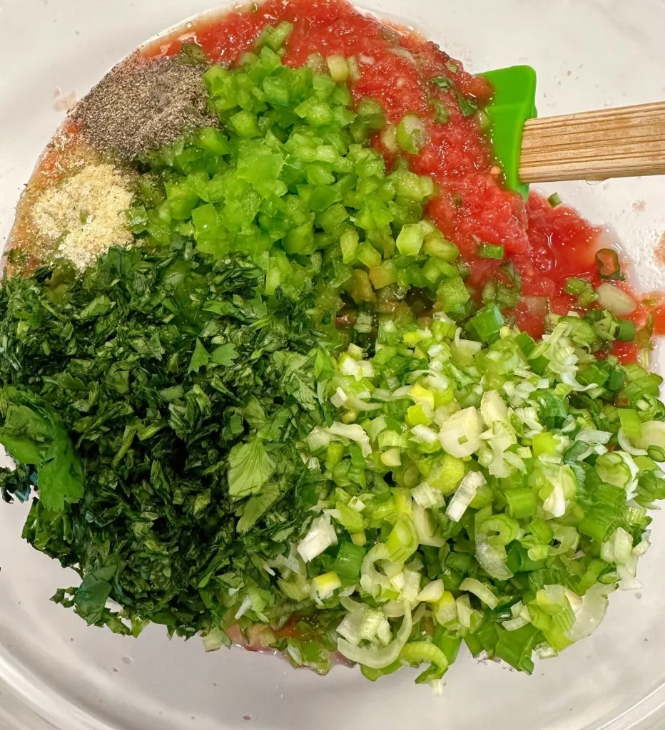 Ingredients for salsa in the bowl with the tomato mixture.