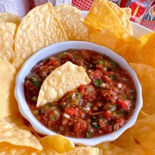 Salsa and chips on a plate.