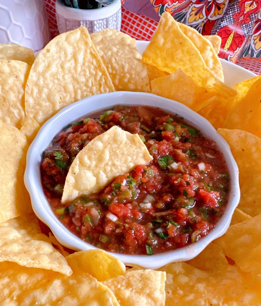 Salsa and chips on a plate.