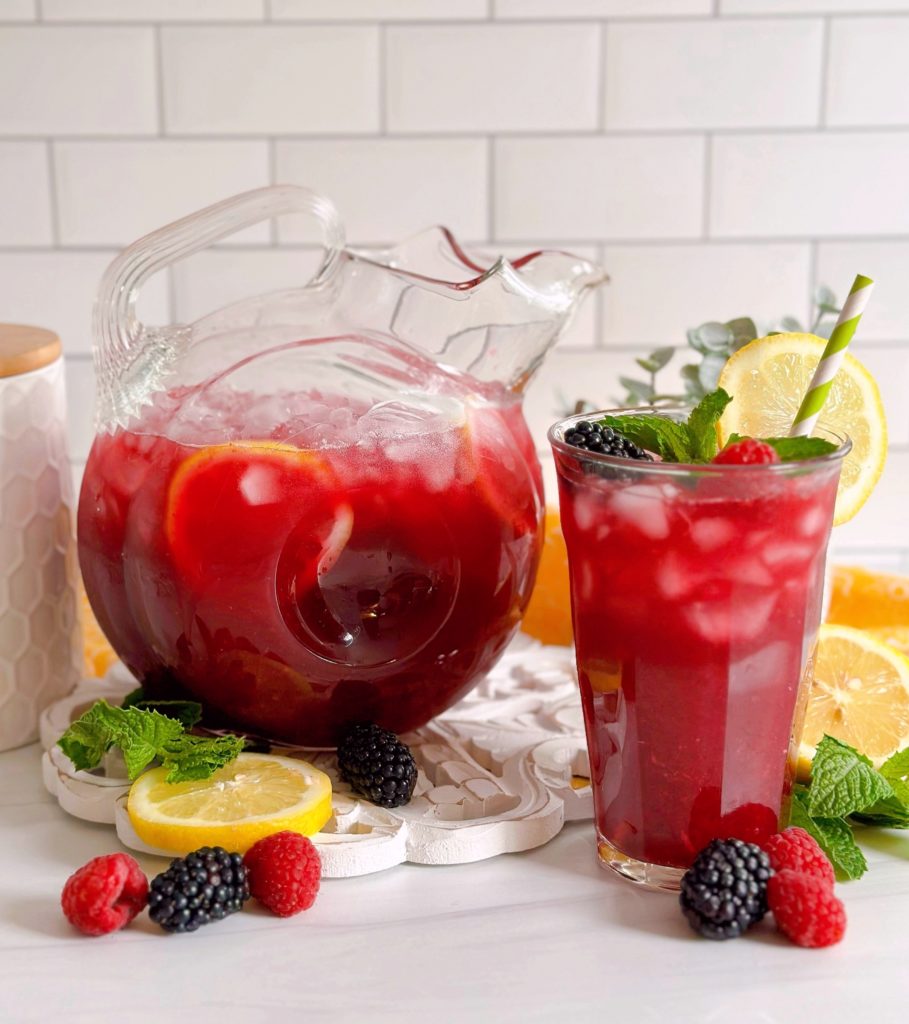 Triple Berry Lemonade in a beautiful pitcher with a tall glass of lemonade next to it.