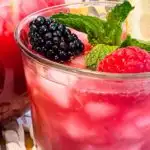 Close up photo of triple berry lemonade in a glass.