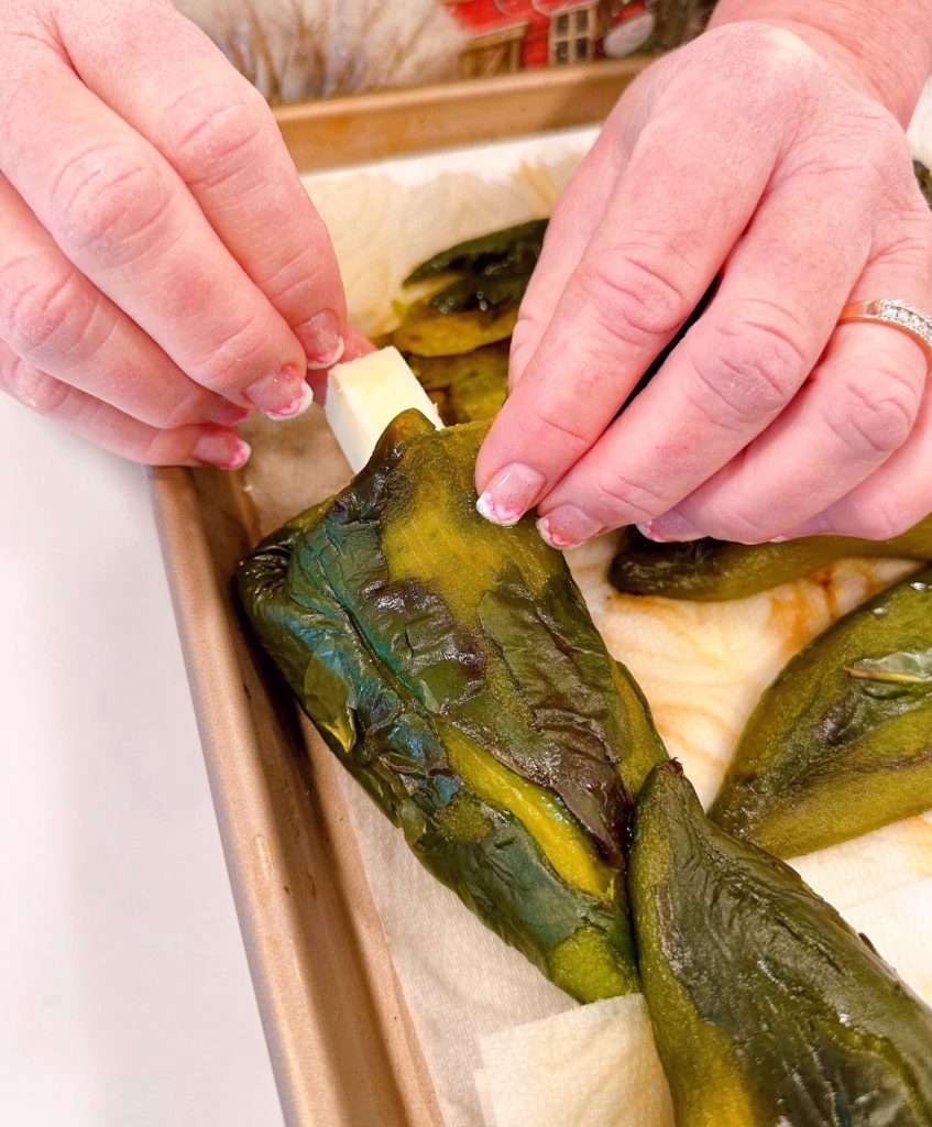 Stuffing cheese in Poblano peppers.