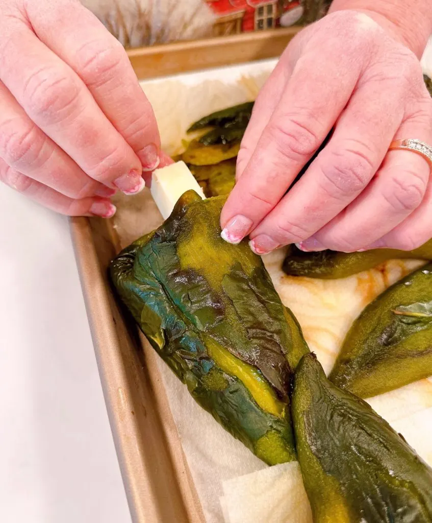 Stuffing cheese in Poblano peppers.