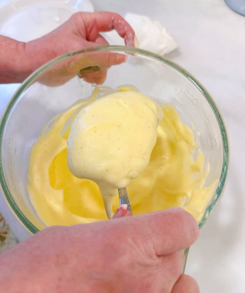 Lifting the stuffed peppers in the egg batter.