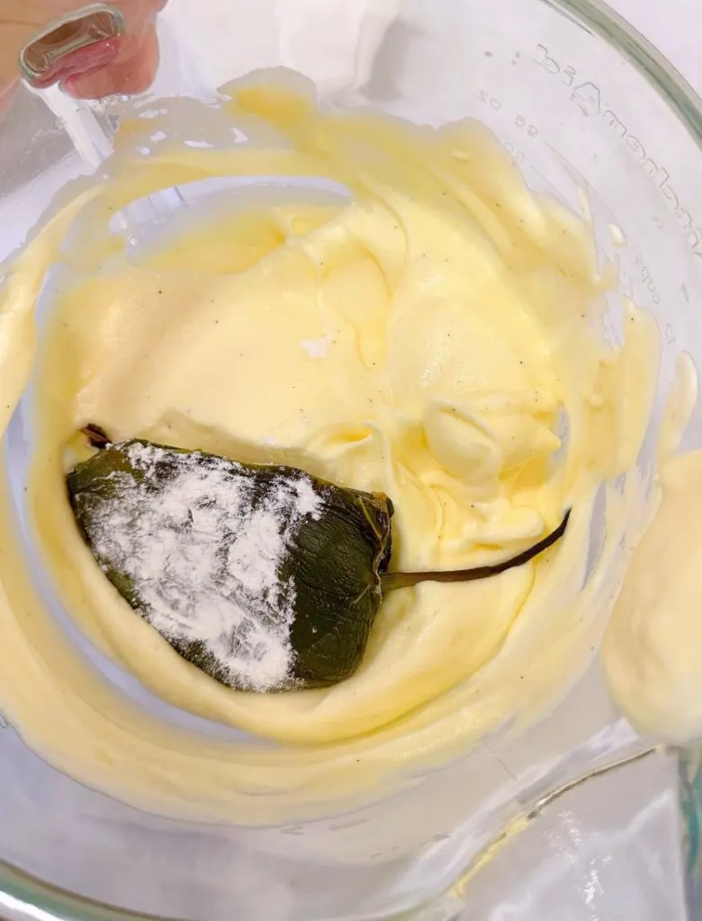 Placing the floured stuffed peppers into the egg batter.