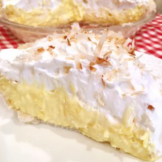 A large slice of easy Coconut Cream Pie on a white plate ready to eat!