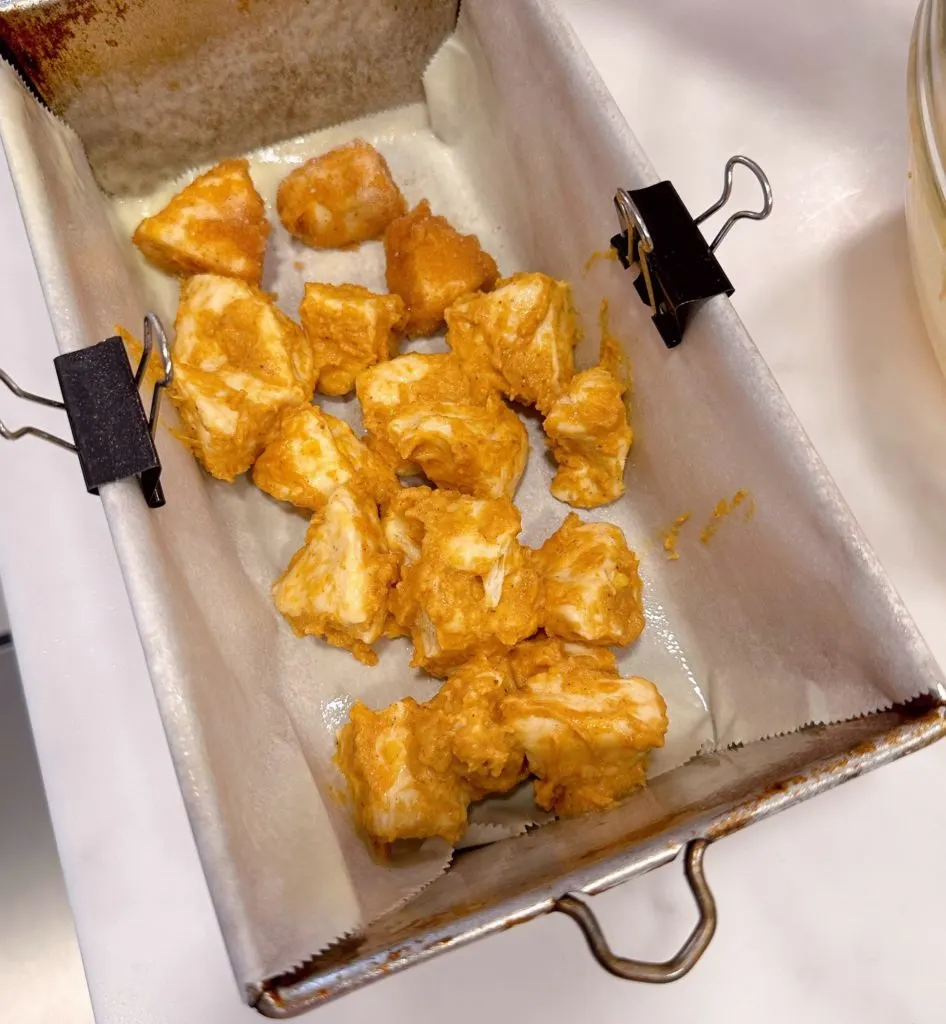 Pumpkin covered biscuit dough layered in the bottom of prepared baking pan.