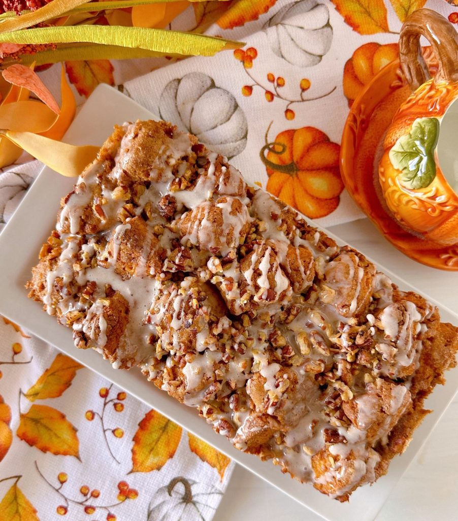 Loaf of Pumpkin Spice Monkey Bread with glaze and nuts.