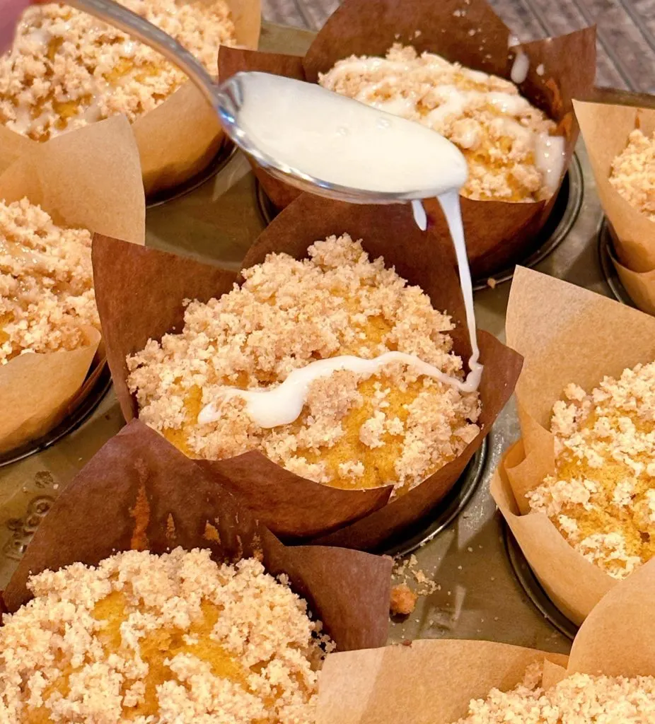 Drizzling the top of each pumpkin streusel muffin with glaze.