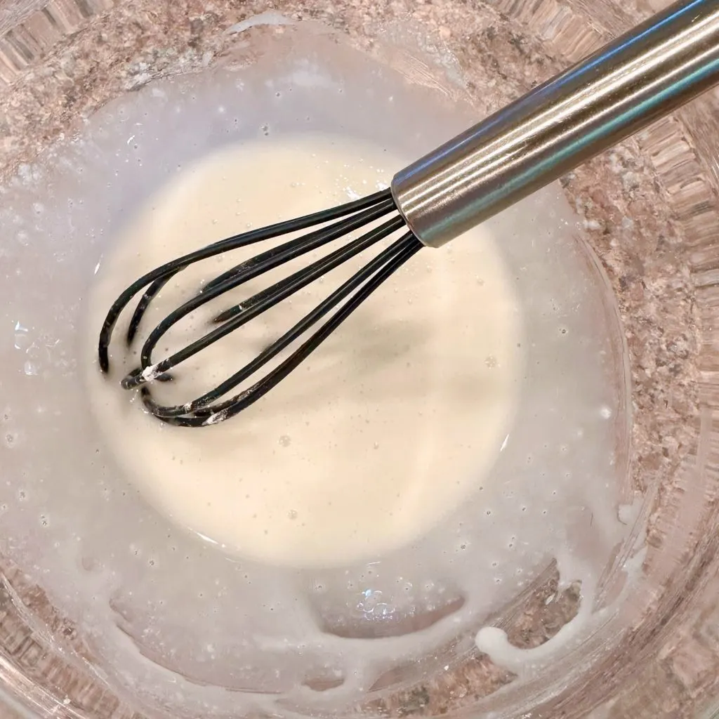 Vanilla glaze in a small bowl with a small whisk.