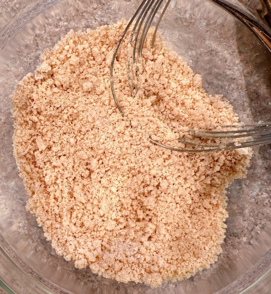 Streusel crumb topping in a bowl with a pastry blender.