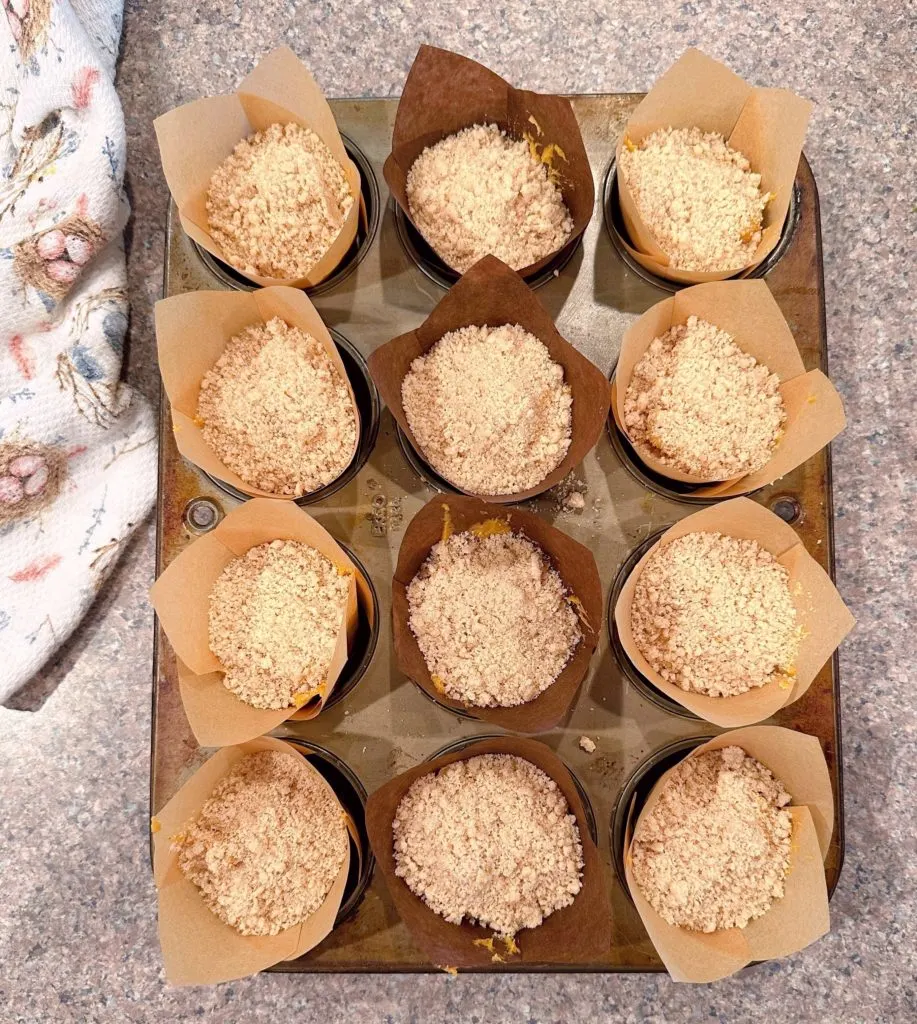 Muffins sprinkled with streusel topping ready to go into the oven.