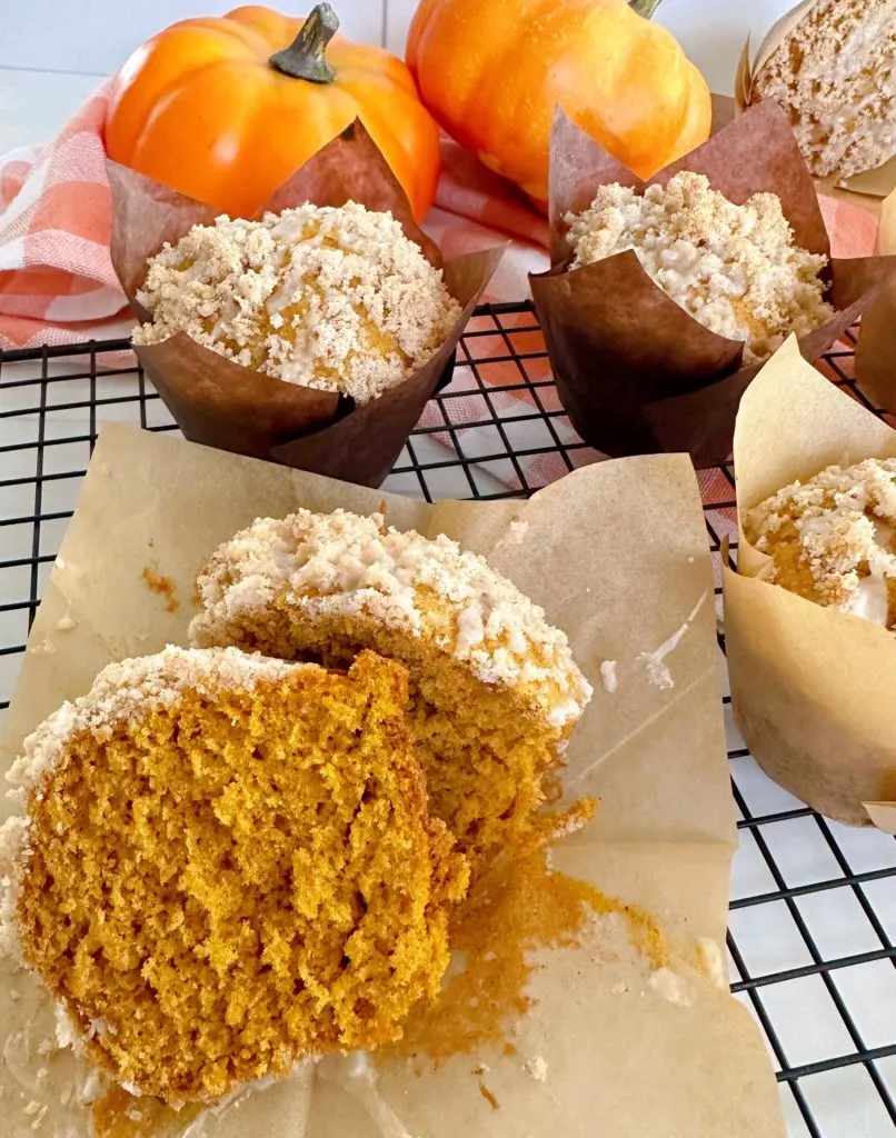 Pumpkin muffin cut open on a cooling rack.