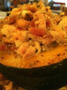 Acorn squash cut in half baked and filled with chicken and stuffing