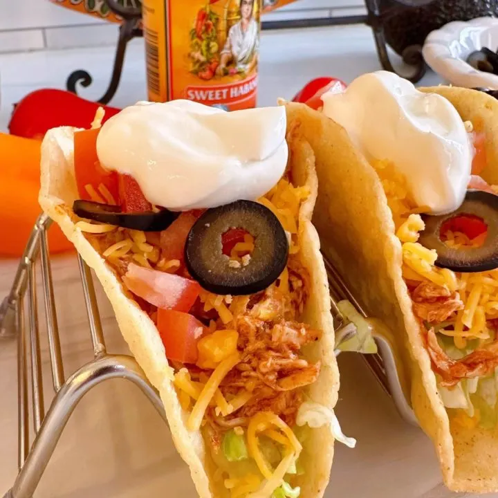 Chicken tacos with sour cream and all the toppings.