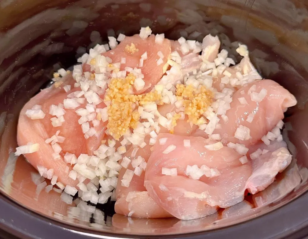 Chicken breast in the bottom of the slow cooker.