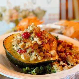 Stuffed Acorn Squash on a plate and festive Fall table setting.