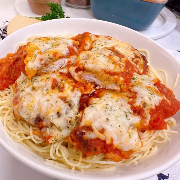 Chicken Parmesan piled high on a bed of spaghetti noodles.