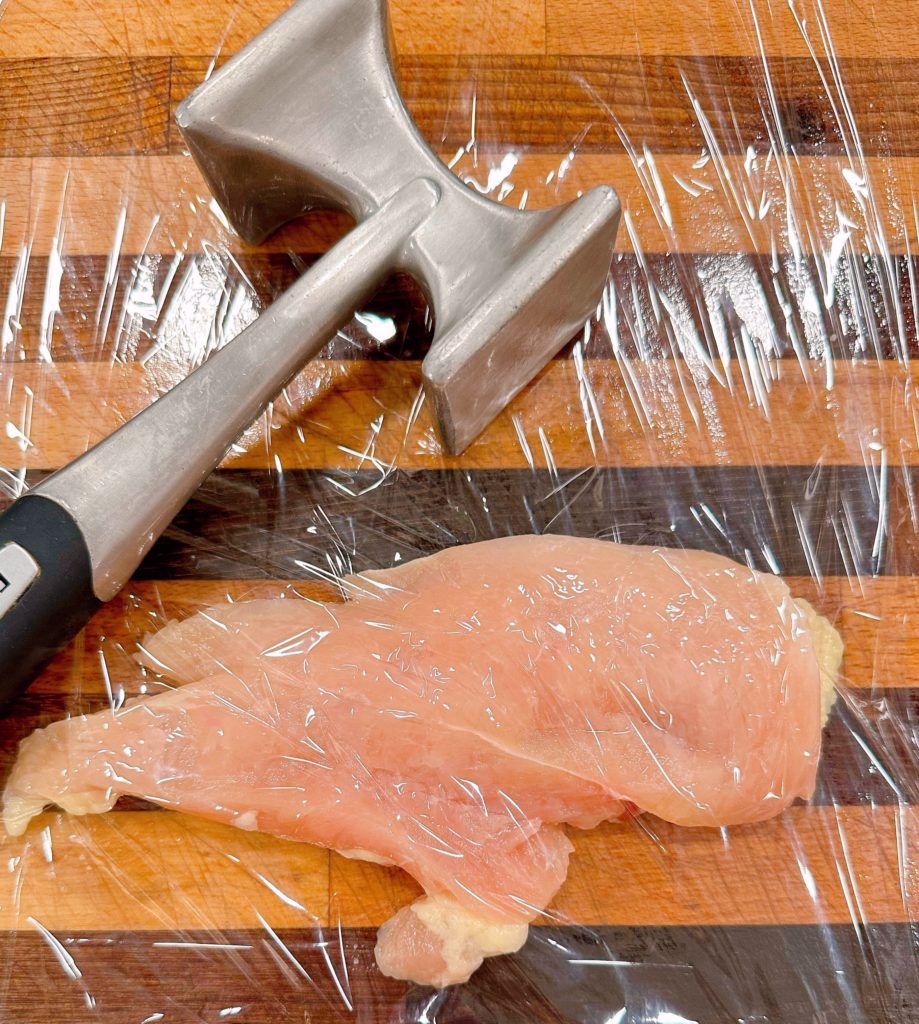 Tenderizing the chicken breast.