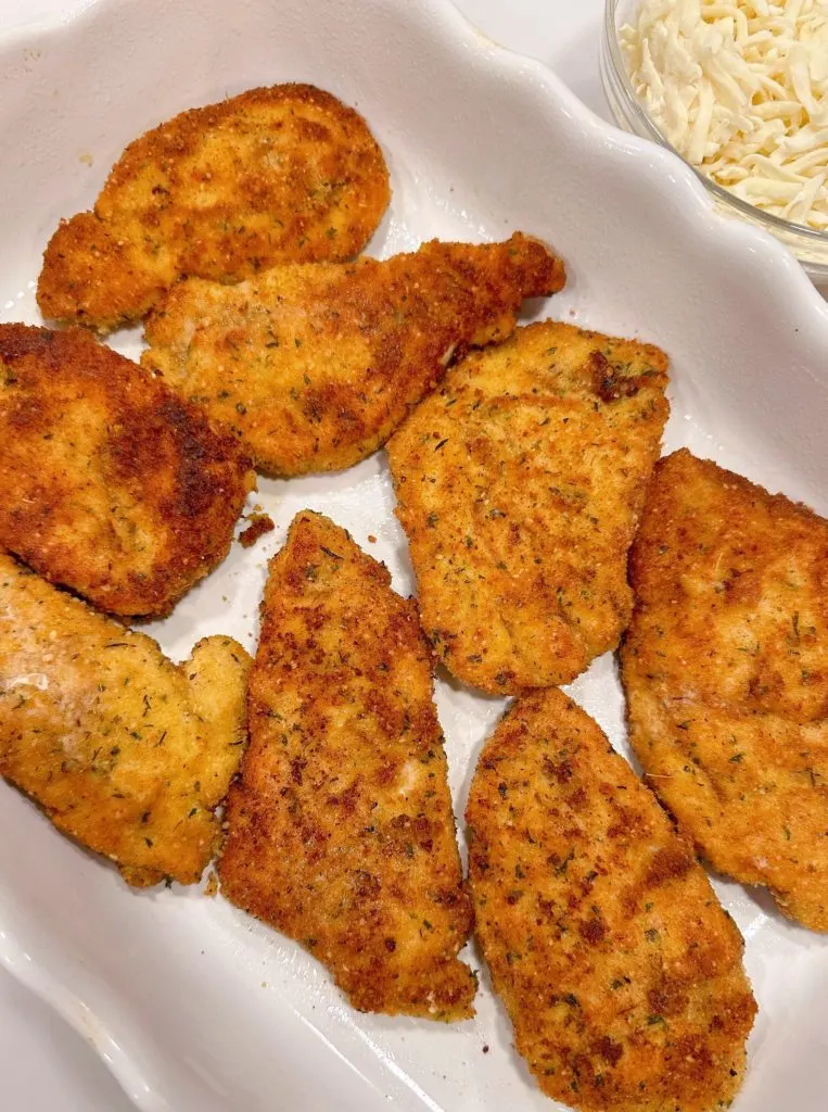 Chicken breast placed in a large baking dish coated with non-stick baking spray.