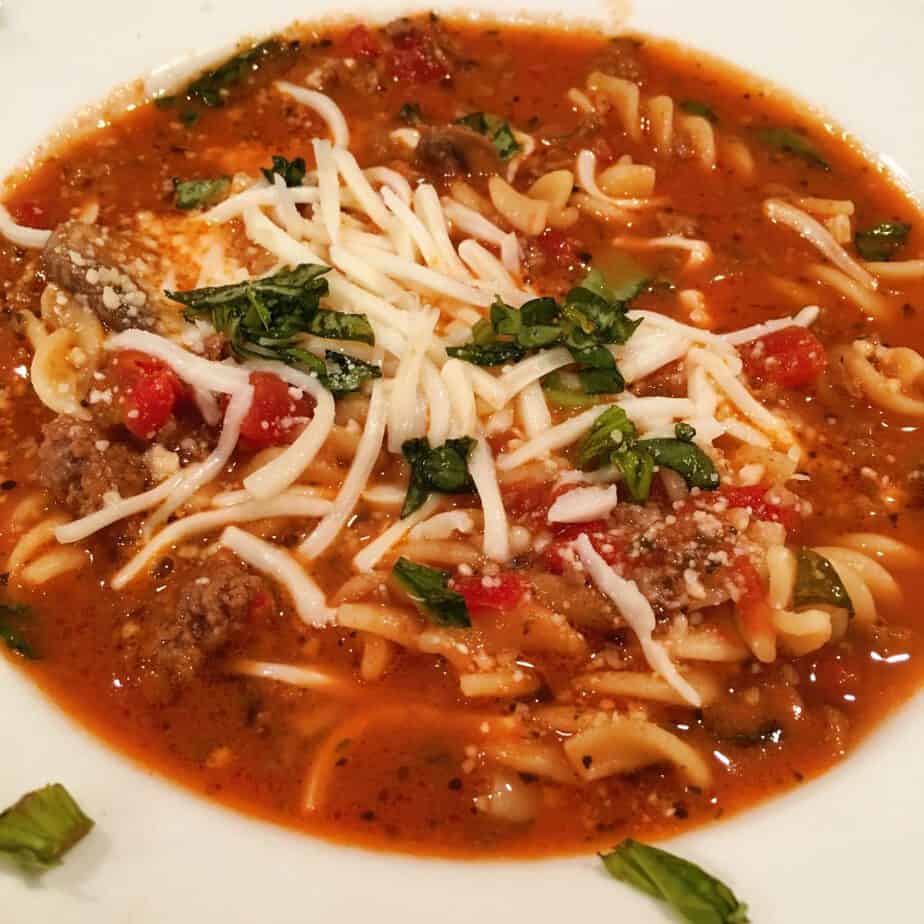 Bowl full of Italian Beefy Noodle Soup with cheese.