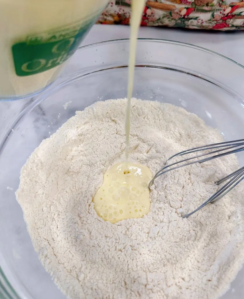 Combining the wet and dry ingredients for the pancake batter.