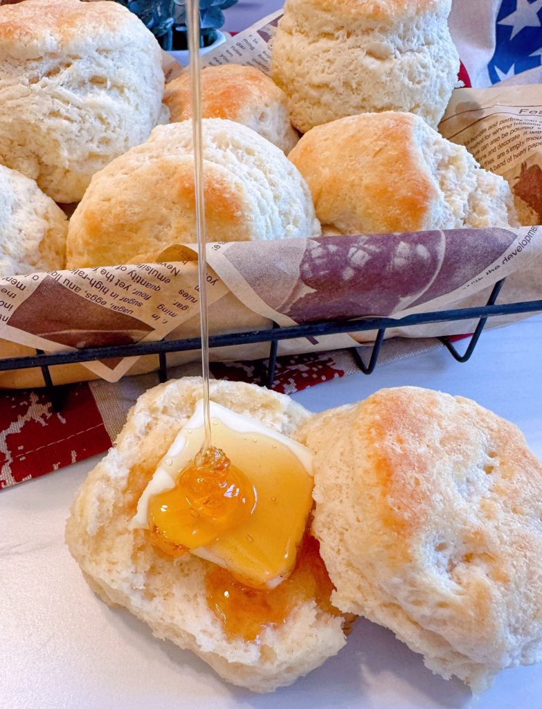 Biscuits with honey being drizzled all over the biscuits.