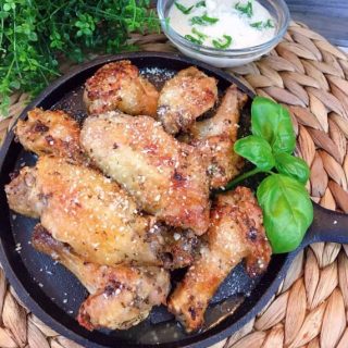 Air Fryer Garlic Parmesan Wings on Cast Iron skillet with dipping sauce.