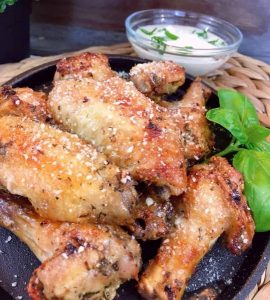 Air Fryer Parmesan Wings on a iron skillet with dipping sauce