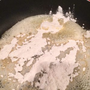 adding flour to melted butter