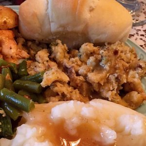 Plate full of roasted chicken with stuffing and roll