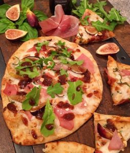 Fig Prosciutto Pizza with hazelnuts and figs on a board