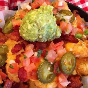 Loaded Tater Tots in a mini cast iron skillet hot out of the oven