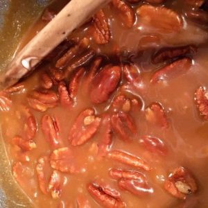 Pecan Halves being stirred into brown sugar mixture.