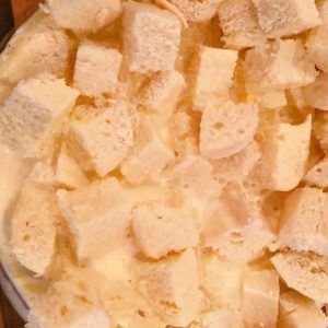 Milk mixture poured over bread in large mixing bowl.