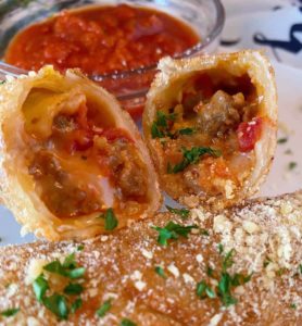 Homemade Pizza Roll cut open and marinara sauce in a bowl.