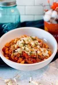 Bowl of One Pot Goulash on the table with melted cheddar.