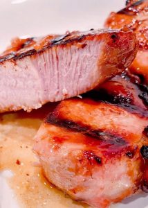 Cooked glazed brown sugar pork chops on a plate.