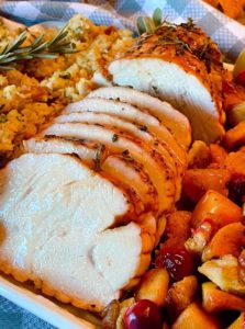 Herb Crusted Turkey Roast on a platter with side dishes.