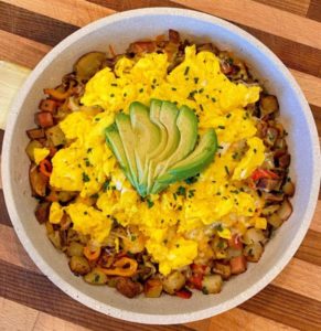 Skillet Breakfast in the skillet on top of a cutting board.