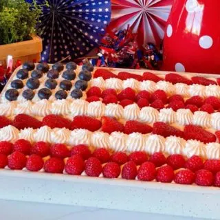 Red, White and Blue Poke Cake with fresh berries decorated like an American Flag.