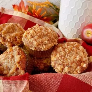 Pumpkin Apple Streusel Muffins on a plaid napkin in a basket.