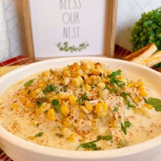 Bowl full of Mexican Chicken Corn Chowder topped with roasted corn, cheese, and cilantro.