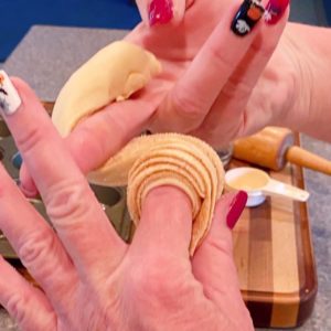 Rolling dough around finger to create muffin for the cruffins.