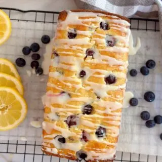 Overhead shot of Lemon Blueberry Bread on a cooling rack with lemon glaze dripping down the sides.