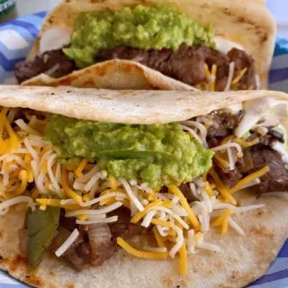 Steak Fajitas on a paper plate.