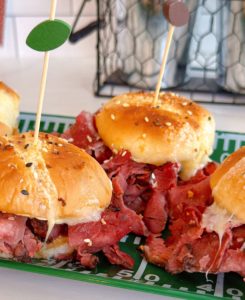 Hot Pastrami and Cheese sliders on a platter.