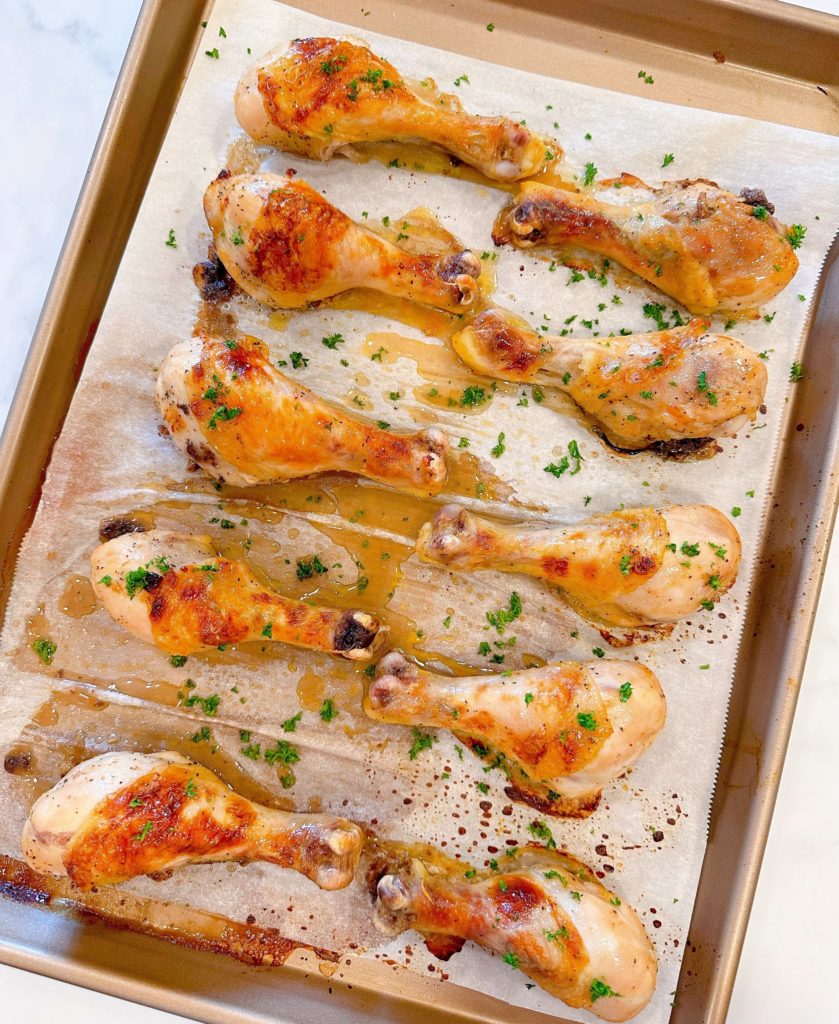 Chicken Drumsticks on a baking sheet with parchment paper baked to a golden brown.