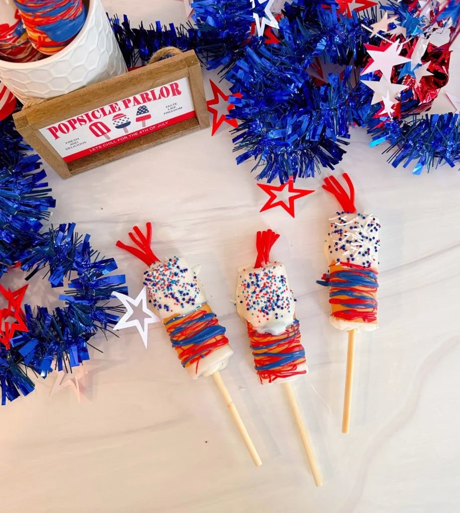 4th of July Cake Pops on a table with patriotic decorations.