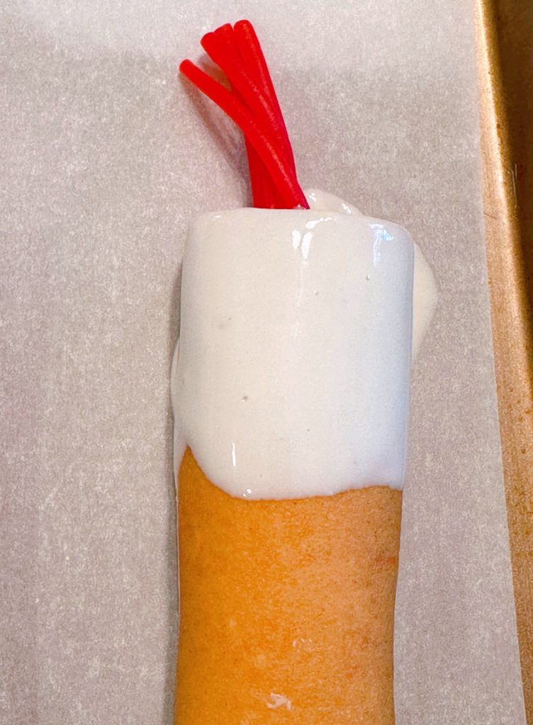Red licorice is placed on the top of each cake roll.
